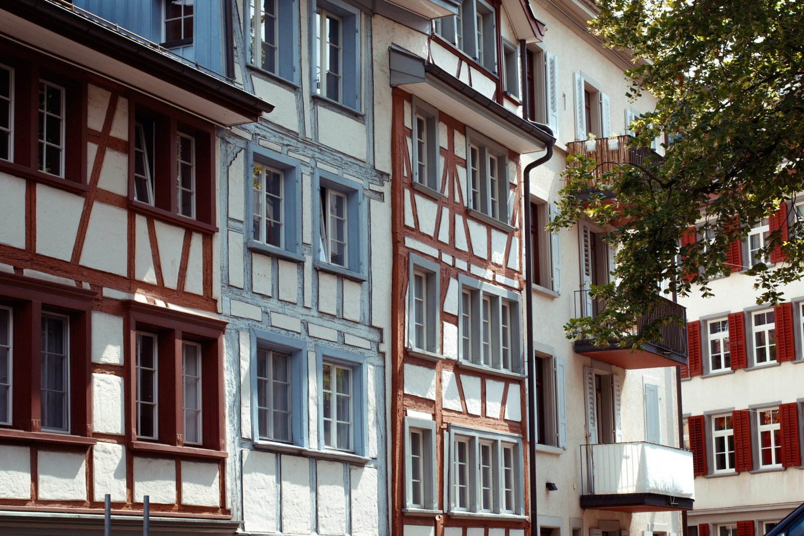 a car is parked in front of a row of multi - colored buildings